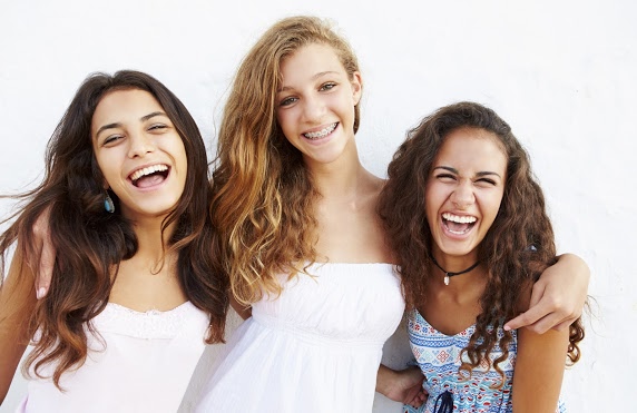 Teen girls smiling with braces